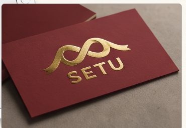 Gold foil SETU mark on lacquer-red board